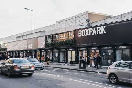 London, UK - December 29, 2019: People and cars in front of shops at BOXPARK Shoreditch, London, shipping container pop-up mall for independent and fashion and lifestyle stores and cafes.のeditorial素材