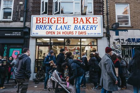 London, UK - December 29, 2019: Facade of Brick Lane Bakery in Brick Lane, people walk in front,...