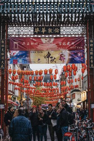 London, UK - November 24, 2019: People walking by Chinatown Gate in Chinatown, London. Chinatown is home to a large East Asian community and is famous for its eateries and events. Selective focus.のeditorial素材