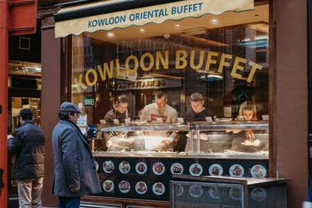 London, UK - November 24, 2019: People outside and inside Kowloon buffet in Chinatown, London....