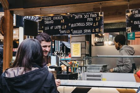 London, UK - November 26, 2019: People ordering food from Grilled Pita stall in Camden Market, London. Started with 16 stalls in 1974, Camden Market is one of the busiest retail destinations in Londonのeditorial素材