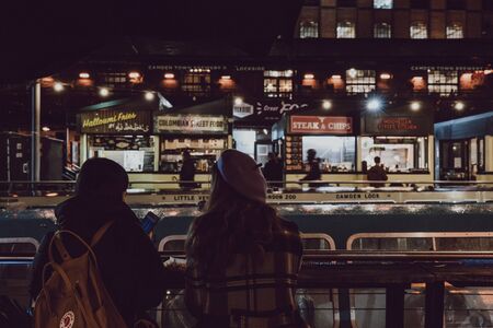London, UK - November 26, 2019: Rear view of two women inside Camden Market, selective focus. Started with 16 stalls in March 1974, Camden Market is one of the busiest retail destinations in London.のeditorial素材
