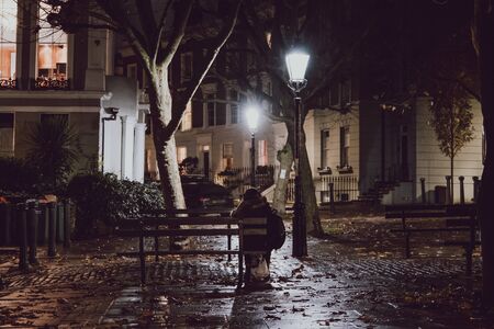 London, UK - November 26, 2019: Rear view of the woman sitting on a bench in Primrose Hill, an...