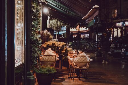 London, UK - November 26, 2019: Cafes and shops in Primrose Hill, an upscale area of North London that got its name from the famous Primrose Hill, in the evening, woman walking past.のeditorial素材