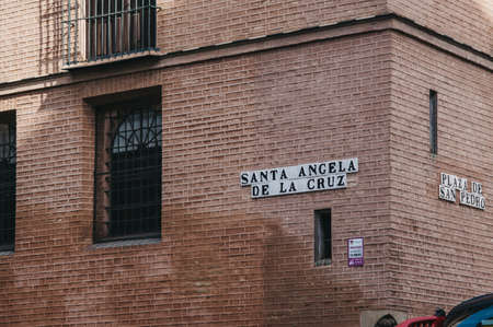 Seville, Spain - January 17, 2020: Street name sign on a wall in Santa Angela de la Cruz in Seville, the capital of Andalusia region in of southern Spain and a popular tourist destination.のeditorial素材