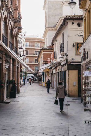 Seville, Spain - January 17, 2020: People walking on a street in Seville, the capital of Andalusia region in Southern Spain and a popular tourist destination. Selective focus.のeditorial素材