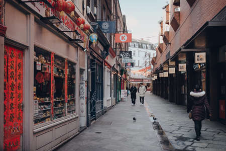 London, UK - March 06, 2020: Few people walk in largely empty Chinatown area in London. Chinatown is home to a large East Asian community and is famous for its eateries and events. Selective focus.のeditorial素材