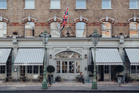 London, UK - March 6, 2020: Woman smoking outside Charlotte Street Hotel in Soho, an area of London...