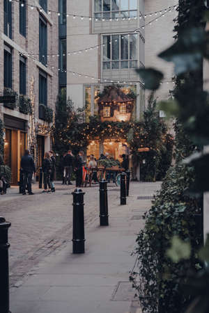London, UK - March 06, 2020: Distant view of people outside a pub in Covent Garden, a famous tourist area in London with lots of shops and restaurants, selective focus.のeditorial素材