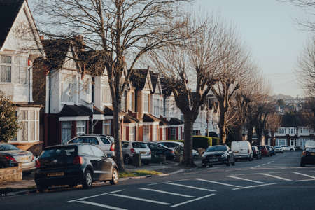 London, UK - March 22, 2020: Cars parked in front of a row of Edwardian houses on a street in Palmers Green, a suburban area of the London Borough of Enfield in north London, England.のeditorial素材