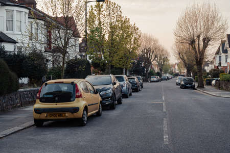 London, UK - April 12, 2020: Cars parked in front of a row of houses on a street in Palmers Green, a suburban area in the London Borough of Enfield in North London, England.のeditorial素材