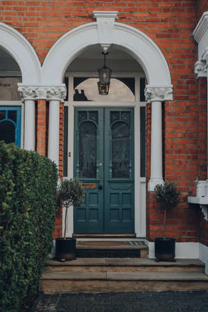 London, UK - April 12, 2020: Stained glass wooden front door of a traditional Edwardian house in...