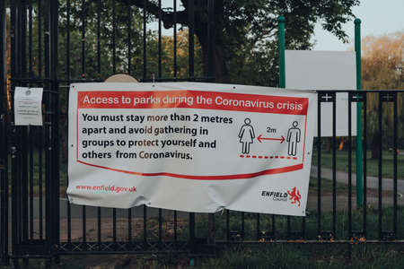 London, UK - April 12, 2020: Notice and guidance about accessing parks on a fence outside Broomfield park in Enfield, London, due to Coronavirus threat.のeditorial素材