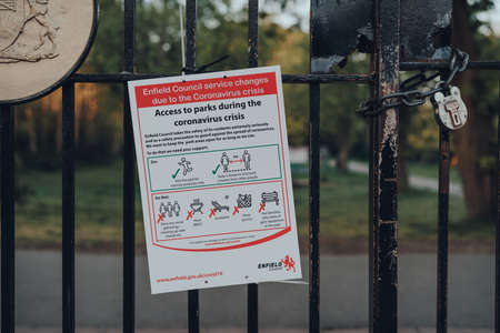 London, UK - April 12, 2020: Notice and guidance about accessing parks on a fence outside Broomfield park in Enfield, London, due to Coronavirus threat.のeditorial素材