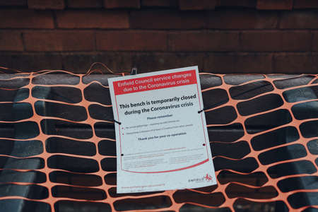 London, UK - April 12, 2020: Covered up bench with a closure notice on a street in Enfield, London,...