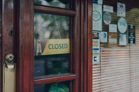 London, UK - April 12, 2020: Close up of a closed sign on a door of Dipali Indian restaurant n Palmers Green, London, as non-essential businesses are closed due to Coronavirus threat.のeditorial素材