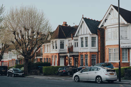 London, UK - April 12, 2020: Cars parked in front of a row of Edwardian houses on a street in Palmers Green, a suburban area in the London Borough of Enfield in North London, England.のeditorial素材