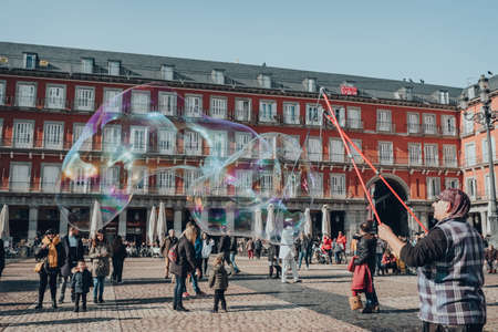 Madrid, Spain - January 26, 2020: Man making soap bubbles in Plaza Mayor, a major public space in the heart of Madrid, the capital of Spain renowned for its rich repositories of European art.のeditorial素材