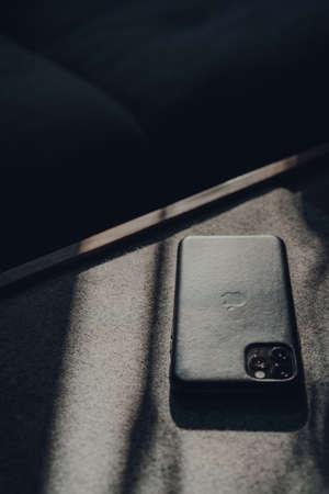 London, UK - May 5, 2020: Apple iPhone 11 Pro Max in leather case on a table, selective focus. Apple launched a tool that reveals changes in the travel behaviour of Maps users during lockdown.のeditorial素材