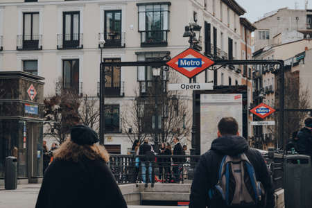 Madrid, Spain - January 26, 2020: Sign at the entrance of Opera Metro station in Madrid, capital of Spain renowned for its rich repositories of European art, people walking past, selective focus.のeditorial素材