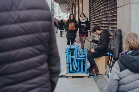 Madrid, Spain - January 26, 2020: Young man play drum pipes while crowd watching on a street in Madrid, capital of Spain renowned for its rich repositories of European art, selective focus.のeditorial素材