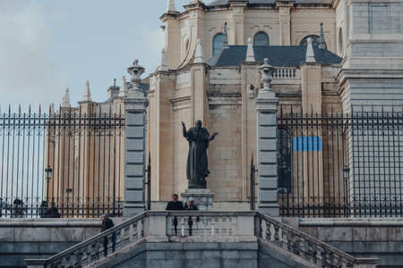 Madrid, Spain - January 26, 2020: People walking past a statue outside Amudena Cathedral (Catedral de la Almudena), a Catholic church and a seat of the Roman Catholic Archdiocese in Madrid, Spain.のeditorial素材