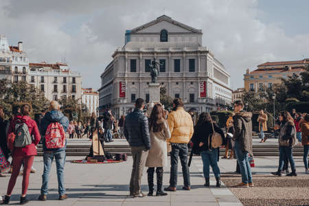 Madrid, Spain - January 26, 2020: Young man playing harp on Plaza de Oriente in Madrid, capital of Spain renowned for its rich repositories of European art, surrounded by spectators, selective focus.のeditorial素材