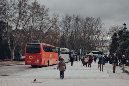 Madrid, Spain - January 26, 2020: Tour buses parked on a street in Madrid, capital of Spain and a popular European city break destination, people walking past, selective focus.のeditorial素材