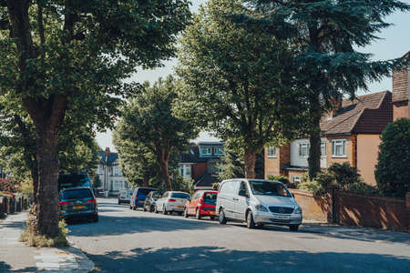London, UK - May 30, 2020: Cars parked in front of a row of houses on a street in Palmers Green, a suburban area in the London Borough of Enfield in North London, England.のeditorial素材