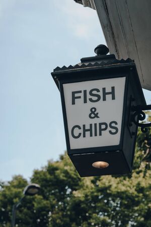 Low angle view of Fish and Chip sign outside a restaurant in London, UK, selective focus.