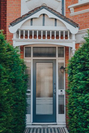 Glass front door of a traditional Edwardian house in London, UK, greenery leading to it, selective focus.の写真素材