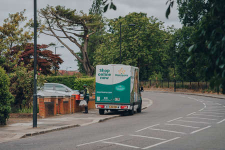 London, UK - April 12, 2020: Morrisons driver delivers food from a van parked on a street in Palmers Green, London. Morrisons is the fourth largest chain of supermarkets in the United Kingdom.のeditorial素材