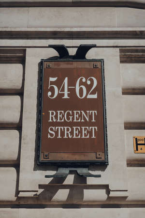 London, UK  - June 13, 2020: Street name sign and building number on Regent Street, a major shopping street in the West End of London, UK, on a summer day.のeditorial素材