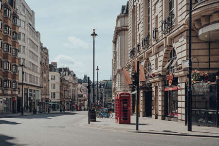 London, UK - June 13, 2020: Red phone booth on empty Haymarket, a street in the St. James area of the City of Westminster, London, famous for its theatres and restaurants.のeditorial素材