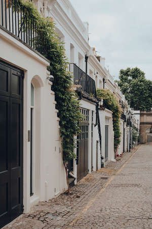 Facade of a typical row of mews houses with garages in London, UK. Real estate and property concept.の写真素材