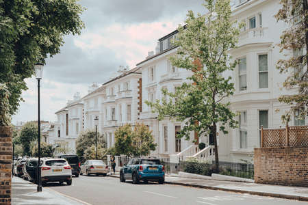 London, UK - June 20, 2020: Cars parked in front of white Victorian houses on a street in Holland park, an affluent area of West London favoured by celebrities.のeditorial素材