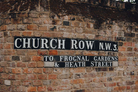 London, UK - July 02, 2020: Street name sign on brick wall in Church Row, Hampstead, London....
