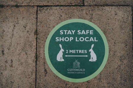 Stow-on-the-Wold, UK - July 6, 2020: Stay Safe Shop Local and 2 metres social distancing green sign...