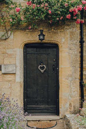 Old wooden front door of a traditional limestone house in Broadway, Cotswolds, UK.の写真素材