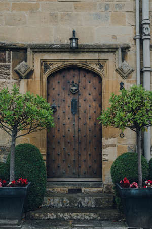 Old wooden front door of a traditional limestone house in Broadway, Cotswolds, UK.の写真素材