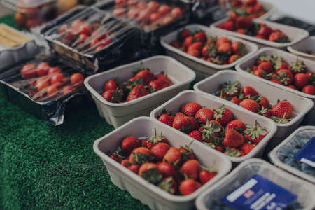 Rows of punnets with fresh strawberries on sale at a local market in the Cotswolds, UK.の写真素材