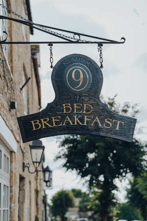 Stow-on-the-Wold, UK - July 10, 2020: Hanging sign outside Number Nine Bed & Breakfast in Stow-on-the-Wold, a market town in Cotswolds, UK, built on Roman Fosse Way.のeditorial素材