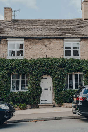 Stow-on-the-Wold, UK - July 10, 2020: Front of a house, partially covered with wall climbing plants in Stow-on-the-Wold, a market town in Cotswolds, UK, build on Roman Fosse Way.のeditorial素材