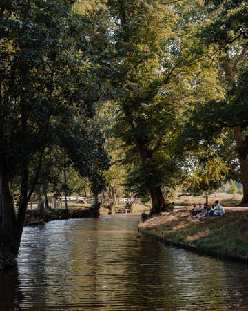 Oxford, UK - August 04, 2020: Group of people relaxing in Christ Church Meadow by River Cherwell in...