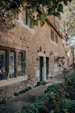 Oxford, UK - August 04, 2020: Traditional English cottages in Oxford, a city in England famous for its prestigious university, established in the 12th century. Selective focus, view through trees.のeditorial素材