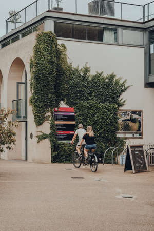 Oxford, UK - August 04, 2020: Couple riding a tandem bike through Oxford Castle Quarter, an area of the city housing Oxford Castle and Prison with a history spanning ten centuries.のeditorial素材