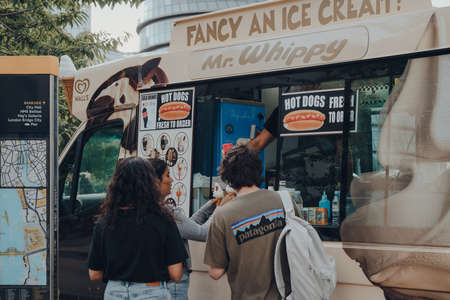 London, UK - August 25, 2020: People getting ice-cream from Mr. Whippy van by Tower Bridge, London....