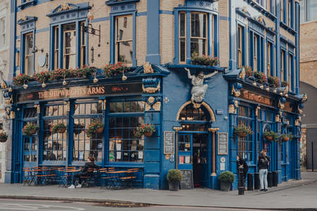 London, UK - August 25, 2020: Exterior of Shipwrights Arms, a traditional English pub located in London Bridge, London, that was built in the mid-late 19th century, few people smoking outside.のeditorial素材