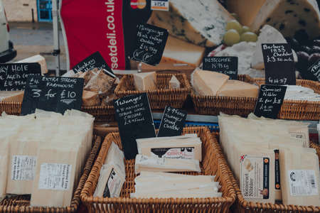 Frome, UK - October 07, 2020: Variety of local cheeses in baskets on sale at a street market in Frome, a market town in the county of Somerset famous for its market and independent shops.のeditorial素材