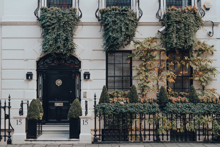 London, UK - December 5, 2020: Facade of greenery covered traditional house in Mayfair, an affluent...
